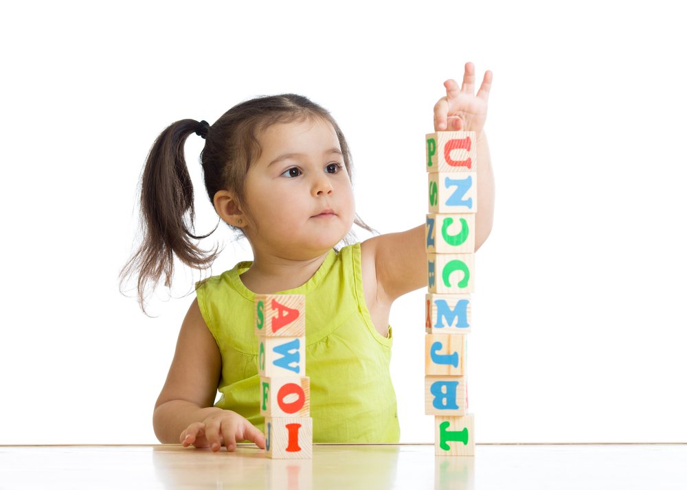 Una niña de dos años juega a hacer una torre con cubos. / De Oksana Kuzmina. / Shutterstock.com.