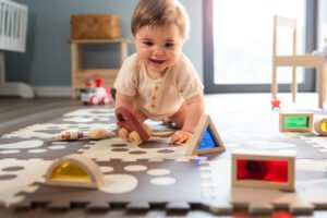Cute happy baby boy playing toys in his child room